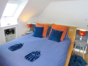 a bedroom with a bed with blue sheets and blue pillows at Drovers Apartment in Tomatin