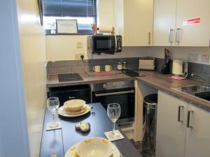 a kitchen with a table with two wine glasses at Drovers Apartment in Tomatin