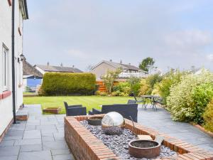 a patio with a fire pit in a yard at Chapel House in Dearham