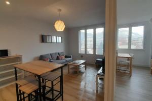 ein Wohnzimmer mit einem Sofa und einem Tisch in der Unterkunft Grenoble appartement pour 4 proche du centre ville in Grenoble