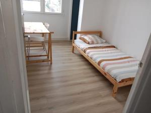 Bett in einem Zimmer mit einem Tisch und einem Schreibtisch in der Unterkunft Grenoble appartement pour 4 proche du centre ville in Grenoble