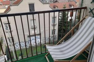 einen Schaukelstuhl auf einem Balkon mit einem Gebäude in der Unterkunft Grenoble appartement pour 4 proche du centre ville in Grenoble