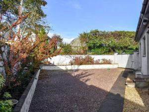 a backyard with a fence and a garden at Kimberley Bungalow in Alness