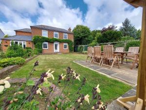 a garden with a table and chairs and a house at St Andrews in Tilmanstone