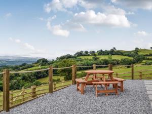 a wooden picnic table and a bench on a patio at Valley View - Uk34178 in Cilycwm