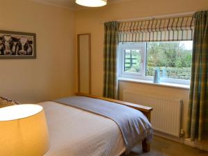 a bedroom with a bed and a window at Westfield Farm Cottage in Seaton Delaval