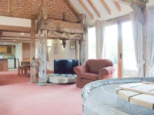 a living room with a tv and a couch and chairs at Woltons Mill in Much Marcle