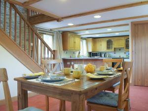 a kitchen with a wooden table with chairs and a dining room at Woltons Mill in Much Marcle