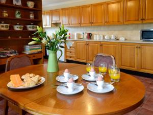 uma mesa de madeira com pratos de comida e copos de sumo de laranja em The Smithy Of Longcastle em Whauphill