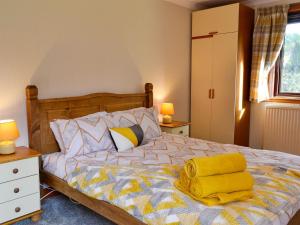 um quarto com uma cama com um cobertor amarelo em The Smithy Of Longcastle em Whauphill