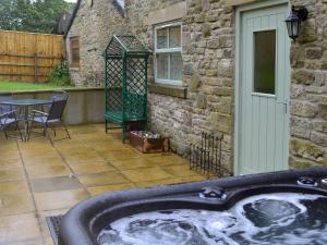 a hot tub on a patio next to a building at Bullions Farm Cottage in Edmondbyers