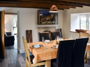 a dining room with a table with chairs and a dog painting at Dewy Lane Farm House in Tansley