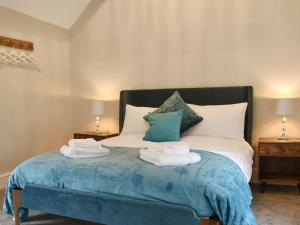 a bedroom with a bed with towels on it at Dewy Lane Farm House in Tansley