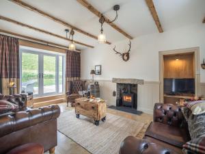 a living room with leather furniture and a fireplace at The Liddel Haven - Uk35337 in Saughtree
