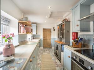 una cocina con armarios blancos y un aparato rosa en The Liddel Haven - Uk35337 en Saughtree