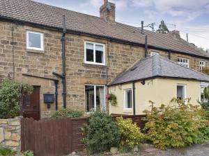 a brick house with a fence in front of it at Front Row Cottage, River View in Ovingham