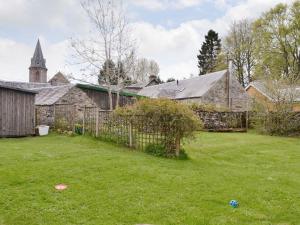 an old stone building with a fence and a yard at Larch Cottage in Balnald