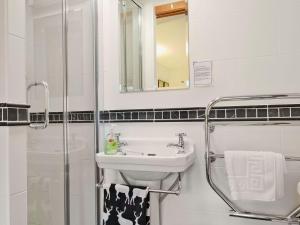 a white bathroom with a sink and a shower at Coulags Croft in Ross on Wye