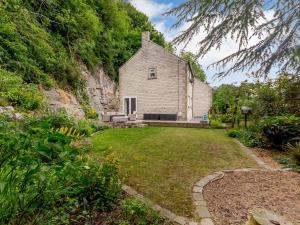 uma casa no lado de uma colina com um quintal em Cliffside House em Matlock