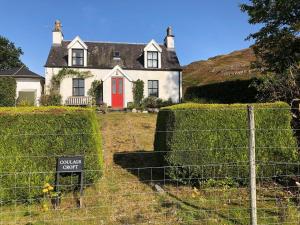 a house with a red door and a fence at Coulags Croft in Ross on Wye