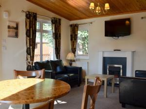 a living room with a couch and a table at Lodge G- Uk33093 in Dinnet