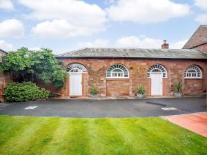 a brick house with white doors and a yard at Corby Castle - Courtyard - Uk34670 in Great Corby