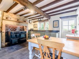 a kitchen with a wooden table and an oven at Sitch Farm in Matlock Bank