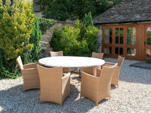 a white table and chairs on a gravel patio at Leonard Barn in Stonehouse