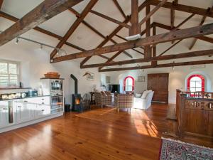 a large living room with wooden floors and wooden beams at The Old Chapel in Gammersgill