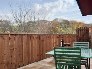 a patio with a table and two chairs on a fence at Pheasant Lodge in Staithes
