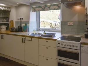een keuken met een wastafel, een fornuis en een raam bij Ramblers Rest - Uk33474 in Nenthead