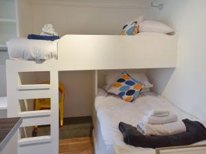2 stapelbedden in een kleine kamer met witte muren bij Ramblers Rest - Uk33474 in Nenthead
