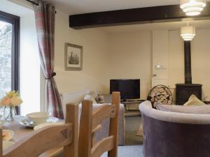 a living room with a table and a fireplace at The Boyne Arms Cottage in Burwarton