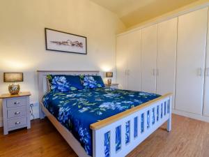 a bedroom with a bed with a blue bedspread at High Nook in Robin Hood's Bay