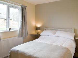 a bedroom with a white bed and a window at Two Dorchester Drive - Uk32036 in Inglewhite