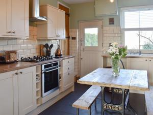 a kitchen with a table with a vase of flowers on it at Dark Lane in Chesterfield