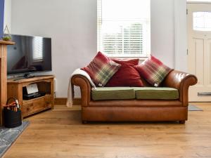 un sofá de cuero marrón con almohadas en la sala de estar en Dark Lane en Chesterfield