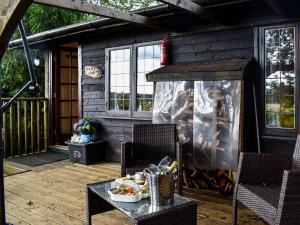 een patio met een tafel en stoelen en een grill bij Toms Cabin - Uk35173 in Elmsted