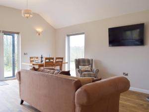 a living room with a couch and chairs and a television at Cadno - Uk32825 in Cwrt-newydd