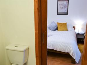 a bathroom with a bed and a toilet in a room at Number 29 in Wooler