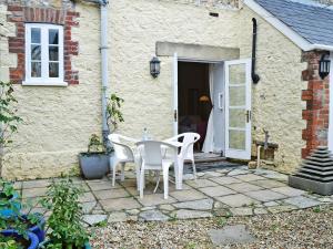 a patio with a table and chairs in front of a house at Porters Lodge in Axminster