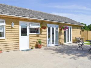 a wooden house with a patio in front of it at The Duck House in Ruckinge