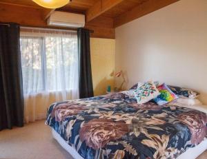 a bedroom with a large bed and a window at Rose Cottage. Cosy, eco-friendly cottage in Yarra Glen. in Yarra Glen