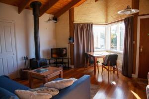 a living room with a blue couch and a table at Rose Cottage. Cosy, eco-friendly cottage in Yarra Glen. in Yarra Glen