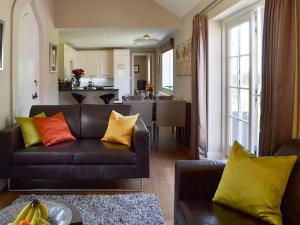 a living room with a black couch with colorful pillows at CoachHouse in Acaster Malbis
