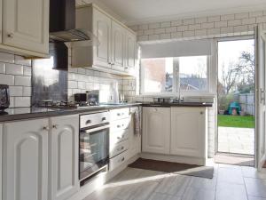 a kitchen with white cabinets and a large window at Oakland in Fleetwood