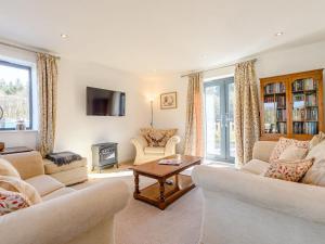 a living room with two couches and a table at The Lodge in Upton Bishop