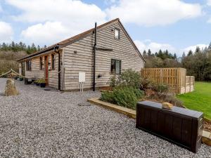 a small wooden cabin with a gravel driveway at The Lodge in Upton Bishop