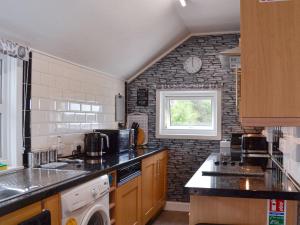 a kitchen with a brick wall and a window at Cuillin View House - Uk12528 in Arisaig