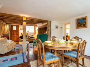 Highlands Farmhouse في Dallington: غرفة معيشة مع طاولة وكراسي خشبية